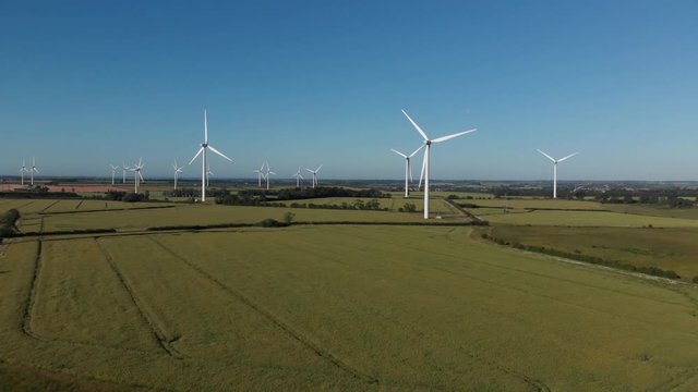 Flying Out From Wind Turbine Farm Over Old Limestone Opencast Mine Northamptonshire Blue Sky Summer Green Crop Fields Aerial 4K