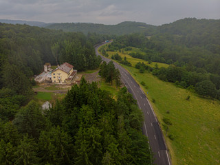 Aerial view over mountain road going through forest landscape. Transylvania, Romania