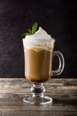 Peppermint coffee mocha for Christmas on wooden table and black background. 