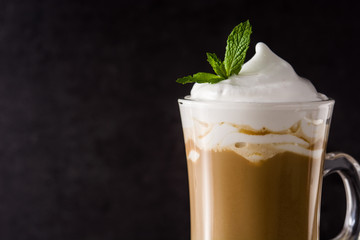 Peppermint coffee mocha for Christmas on wooden table and black background. 
