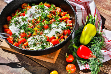 fried eggs with vegetables in a pan