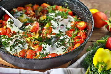 fried eggs with vegetables in a pan