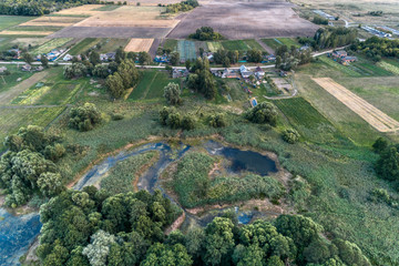 Rural landscape from the air. Many small rural houses. Village streets are shared by a shallow lake.
