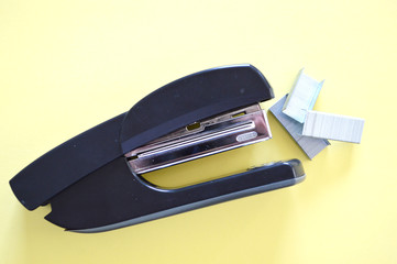 black office stapler on side and staples isolated