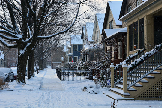 Fresh snow covers the sidewalk in a residential neighborhood of Chicago