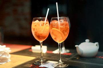 Two cocktails with orange on bar in restaurant