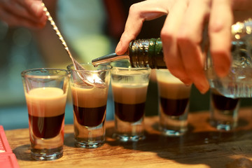 Barman make alcoholic shots with rum and liquor