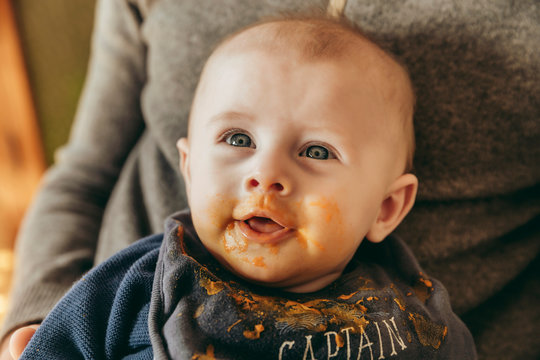 Sattes Baby nach erstem Babybrei auf Papas Scho&szlig;