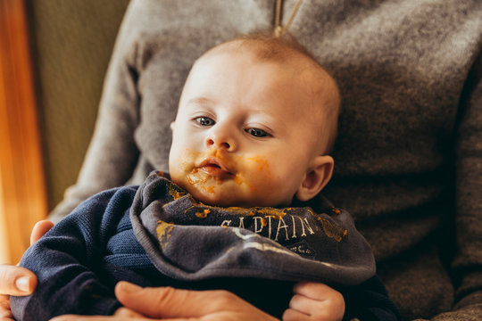 Sattes Baby nach erstem Babybrei auf Papas Scho&szlig;