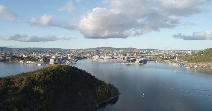 Cinema 4K drone shot with backward reveal motion of Hoved&oslash;ya island, the Oslofjord and the Bj&oslash;rvika project with the Lambda Edvard Munch Museum and Oslo Opera House in autumn fall, in Oslo Norway.