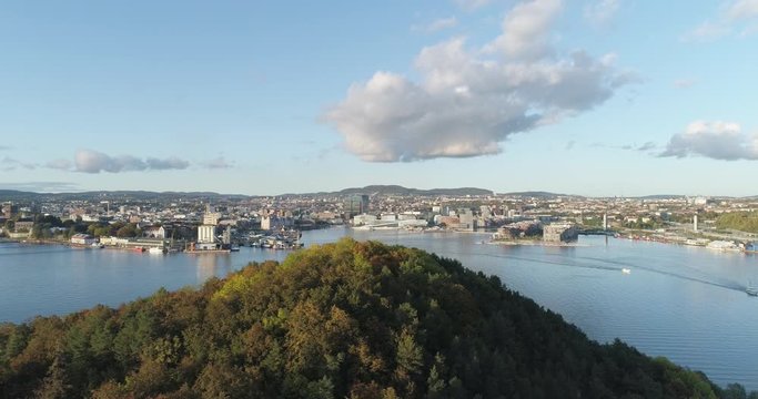 Cinema 4K drone shot with parallax motion of Hoved&oslash;ya island, the blue Oslofjord and the new Bj&oslash;rvika quarter project with the Lambda Munch Museum and Oslo Opera House in autumn fall, in Oslo Norway.