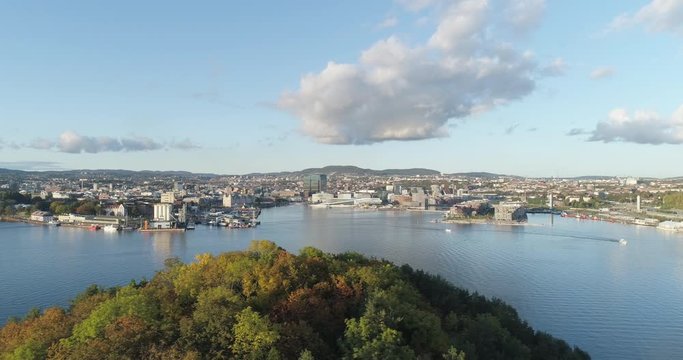 Cinema 4K drone shot with slide motion of Hoved&oslash;ya island, the blue Oslofjord and the new Bj&oslash;rvika quarter project with the Lambda Munch Museum and Oslo Opera House in autumn fall, in Oslo Norway.