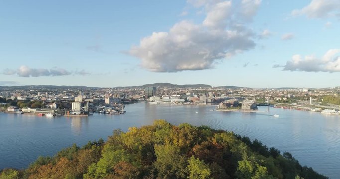 Cinema 4K drone shot with slide motion of Hoved&oslash;ya island, the blue Oslofjord and the new Bj&oslash;rvika quarter project with the Lambda Munch Museum and Oslo Opera House in autumn fall, in Oslo Norway.