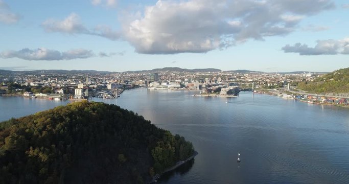 Cinema 4K drone shot with forward tilt reveal motion of Hoved&oslash;ya island, the blue Oslofjord and the Bj&oslash;rvika project with the Lambda Edvard Munch Museum and Opera House in autumn fall, in Oslo Norway.