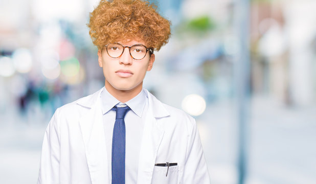 Young handsome scientist man wearing glasses Relaxed with serious expression on face. Simple and natural looking at the camera.