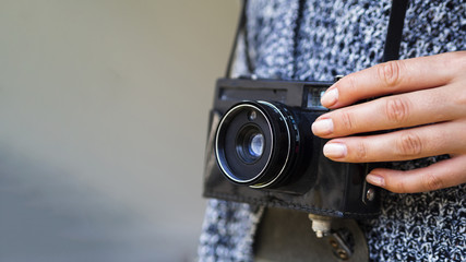 Close-up of a retro photo camera held by a woman
