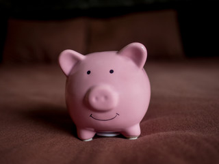 pink piggy bank on dark red bed background, Saving money for future plan and retirement fund concept
