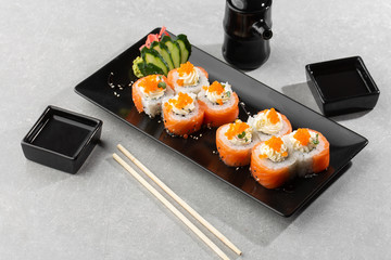 Philadelphia roll sushi with salmon, avocado, cream cheese and red caviar. Sushi menu. on dark plate. Traditional japanese seafood, healthy food concept. Top view horizontal photo on white background.