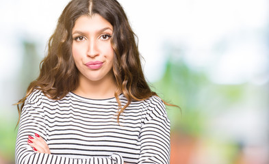 Young beautiful woman wearing stripes sweater skeptic and nervous, disapproving expression on face...
