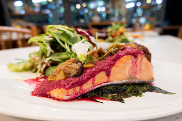 Salmon fish steak, Organic vegetable salad and rice Raspberry in a white dish with mashed potatoes