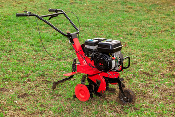 Obraz premium Gasoline cultivator for small agricultural works on green grass field