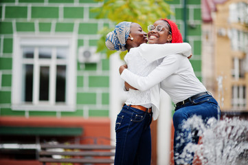Two young modern fashionable, attractive, tall and slim african muslim womans in hijab or turban head scarf posed together.