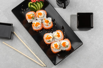 Philadelphia roll sushi with salmon, avocado, cream cheese and red caviar. Sushi menu. on dark plate. Traditional japanese seafood, healthy food concept. Top view horizontal photo on white background.