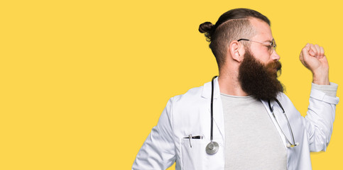 Young blond doctor man with beard wearing medical coat stretching back, tired and relaxed, sleepy...