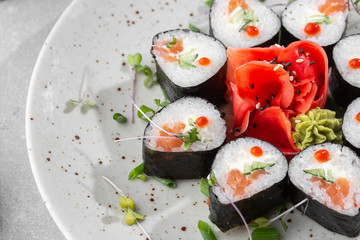 Maki rolls with salmon, cucumber, caviar and cheese. Fresh hosomaki pieces with rice and nori. Closeup of delicious japanese food. Sushi menu. Top view horizontal photo on white background.