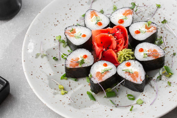 Maki rolls with salmon, cucumber, caviar and cheese. Fresh hosomaki pieces with rice and nori. Closeup of delicious japanese food. Sushi menu. Top view horizontal photo on white background.