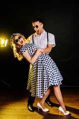 Happy couple in love laughs and have fun. The guy and his girlfriend in a relationship hug and look at each other. Love story of two young people. The dress is retro. Emotional photography