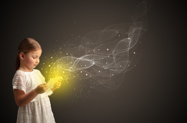 Little cute girl playing on sparkling tablet