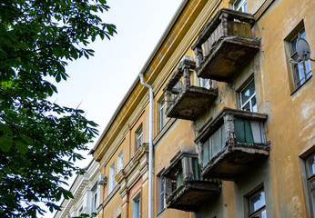 Fototapeta na wymiar Voronezh, Russia, June 17, 2019: Destroyed balconies on facade of residential building. Close-up. Facade of building with ruined balconies overlooks street. Close-up. City life.