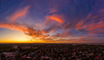 Aerial view amazing sunset over of the suburbs with the city, Giant smoke stack in industrial, far villages and fields