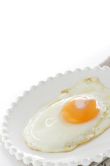 Sunny side up fried egg on white dish