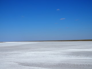 white surface of the lake covered with salt at sunrise