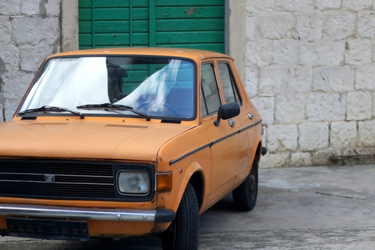 March 12, 2019: Orange vintage Zastava car, manufactured in the former Yugoslavia, parked in a traditional Mediterranean street in Split, Croatia.