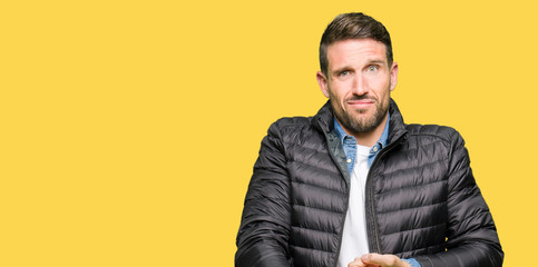 Handsome man wearing winter coat In hurry pointing to watch time, impatience, upset and angry for...