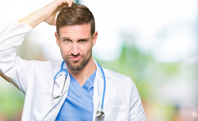 Handsome doctor man wearing medical uniform over isolated background confuse and wonder about question. Uncertain with doubt, thinking with hand on head. Pensive concept.