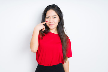 Beautiful brunette woman wearing red t-shirt over isolated background Pointing to the eye watching you gesture, suspicious expression