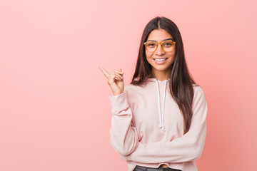 Young pretty arab woman wearing a casual sport look smiling cheerfully pointing with forefinger...