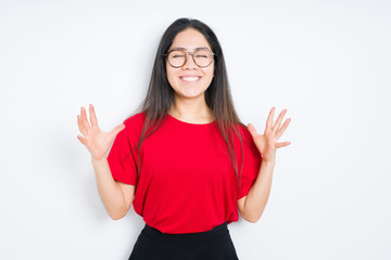 Obraz na płótnie Canvas Beautiful brunette woman wearing glasses over isolated background celebrating mad and crazy for success with arms raised and closed eyes screaming excited. Winner concept