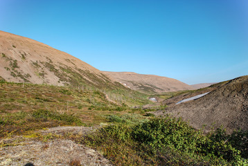 Steep rocky mountains and rocks near the city of Norilsk, Russia. Dirty emissions from industrial plants turn nature into a desert.
