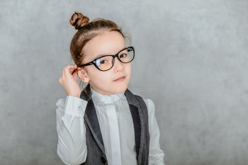 Close up of a small business lady on a gray background. During this In the glasses. Look into the camera.