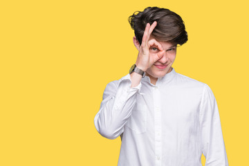 Obraz premium Young handsome business man over isolated background doing ok gesture with hand smiling, eye looking through fingers with happy face.