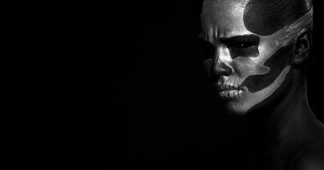 Halloween. Woman in day of the dead mask skull face art. Halloween face art on black background. Halloween make up.