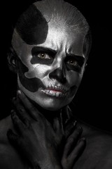 Halloween. Woman in day of the dead mask skull face art. Halloween face art on black background. Halloween make up.