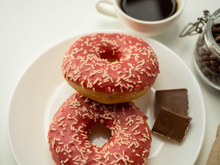 Różowy donut z posypką. Kawa i czekolada. Widok z góry, jasne tło. © PhotoHunter