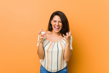 Young curvy woman upset screaming with tense hands.