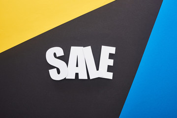 top view of sale lettering on blue, yellow and black background